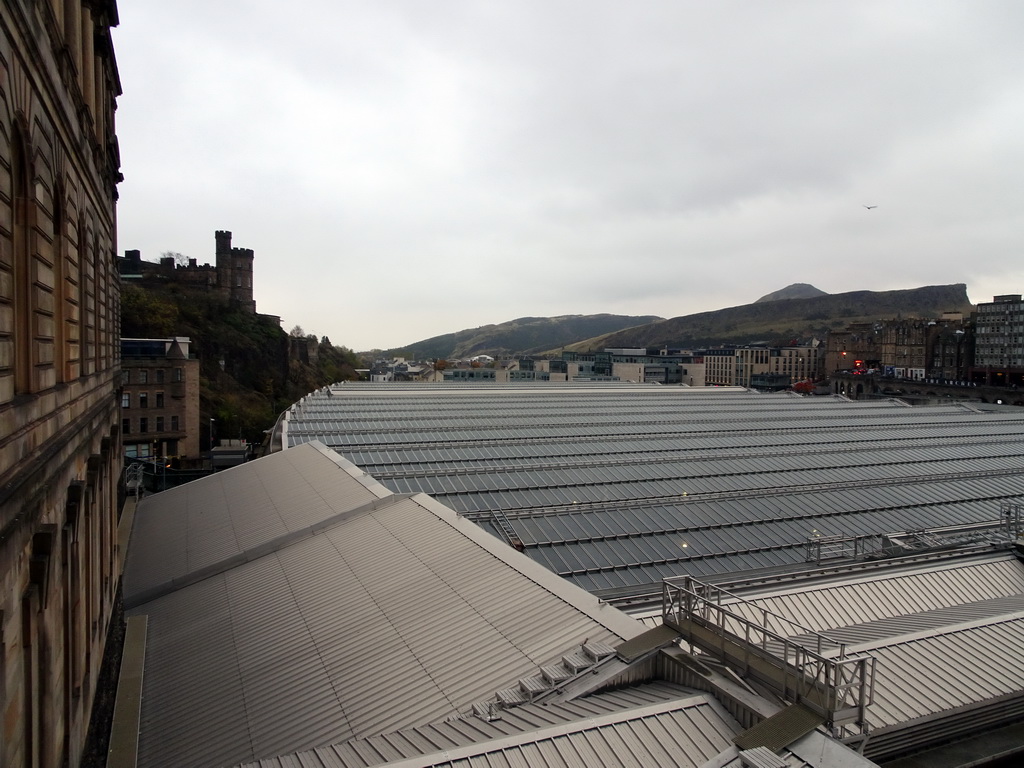 The Edinburgh Waverley railway station, Calton Hill with the Old Calton Burial Ground, and Holyrood Park with the Salisbury Crags and Arthur`s Seat, viewed from North Bridge