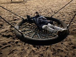 Max on a swing at the main playground at the Landal Coldenhove holiday park, by night