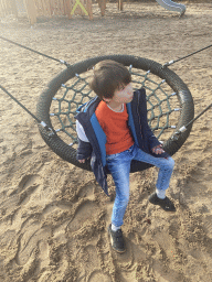 Max on a swing at the main playground at the Landal Coldenhove holiday park, by night