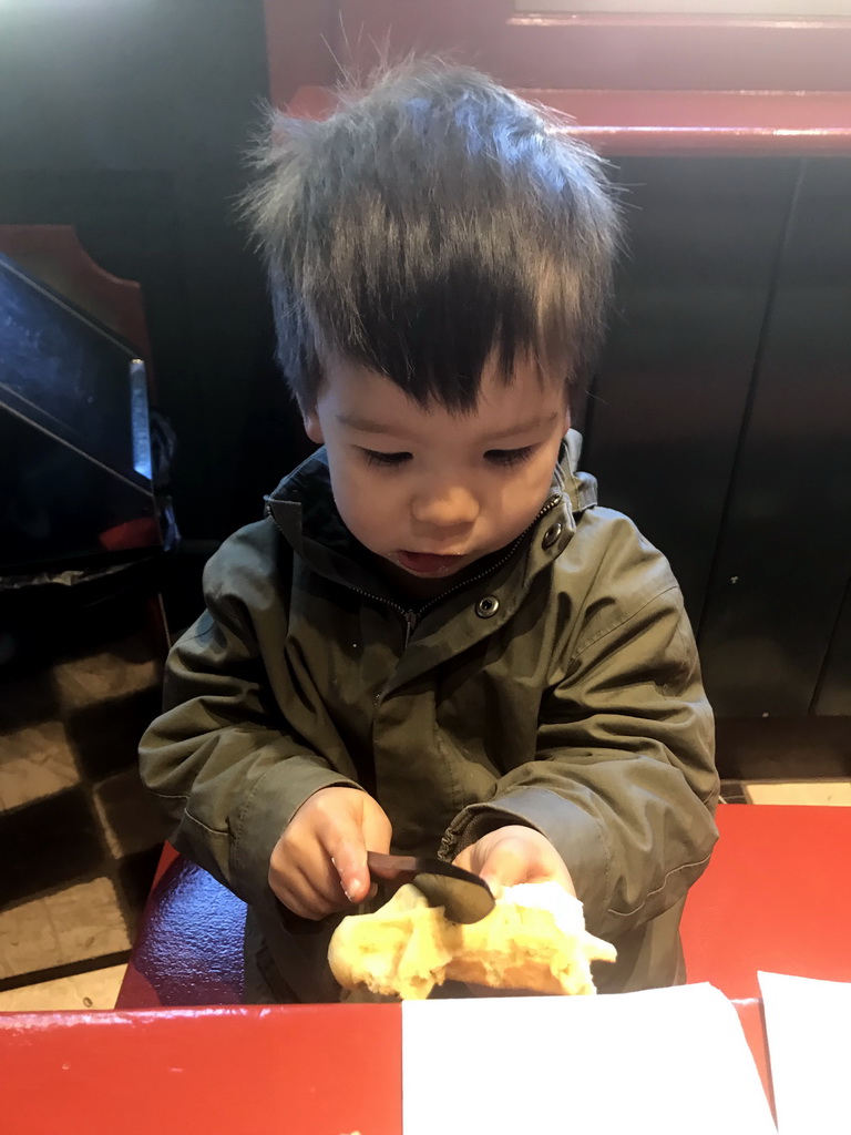 Max eating a waffle at the Den Suykerbuyk restaurant at the Anton Pieck Plein square at the Marerijk kingdom