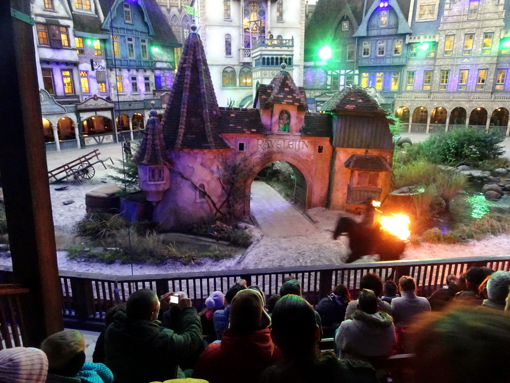 Actor, horse and fire on the stage of the Raveleijn theatre at the Marerijk kingdom, during the Raveleijn Parkshow at the Winter Efteling, at sunset