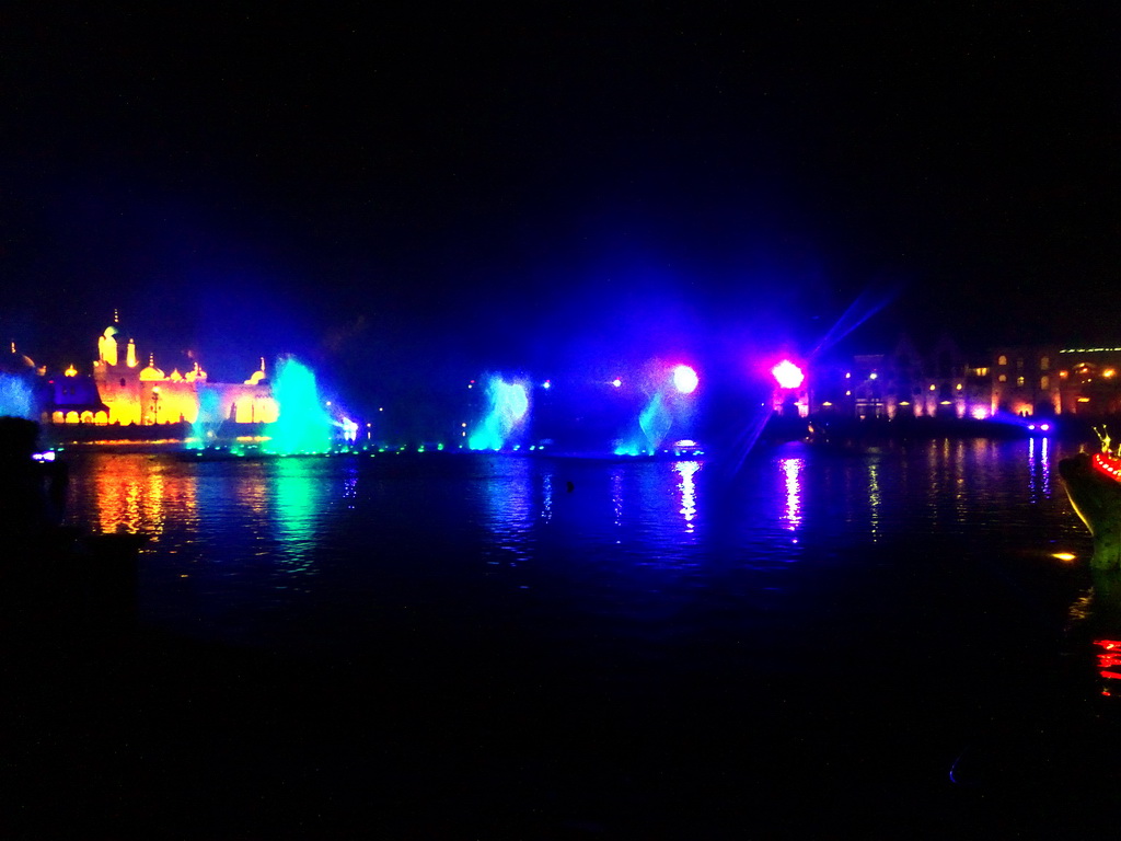 The Aquanura lake at the Fantasierijk kingdom, and the Fata Morgana attraction and the Efteling Theatre at the Anderrijk kingdom, during the water show at the Winter Efteling, by night