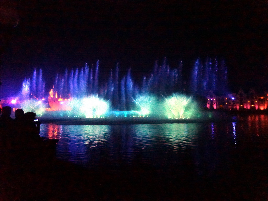 The Aquanura lake at the Fantasierijk kingdom, and the Fata Morgana attraction and the Efteling Theatre at the Anderrijk kingdom, during the water show at the Winter Efteling, by night