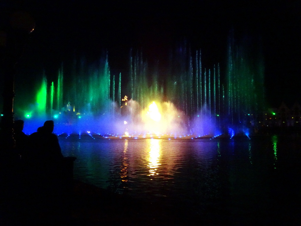 The Aquanura lake at the Fantasierijk kingdom, and the Fata Morgana attraction and the Efteling Theatre at the Anderrijk kingdom, during the water show at the Winter Efteling, by night