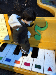 Max on a piano at the Kleuterhof playground at the Reizenrijk kingdom, during the Winter Efteling, at sunset