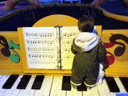 Max on a piano at the Kleuterhof playground at the Reizenrijk kingdom, during the Winter Efteling, at sunset