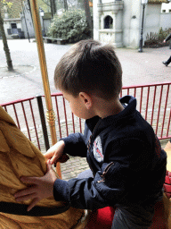 Max on a rooster statue at the Vermolen Carousel at the Anton Pieck Plein square at the Marerijk kingdom