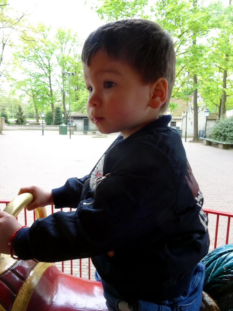 Max on a rooster statue at the Vermolen Carousel at the Anton Pieck Plein square at the Marerijk kingdom