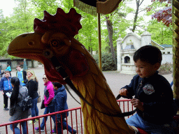 Max on a rooster statue at the Vermolen Carousel at the Anton Pieck Plein square at the Marerijk kingdom