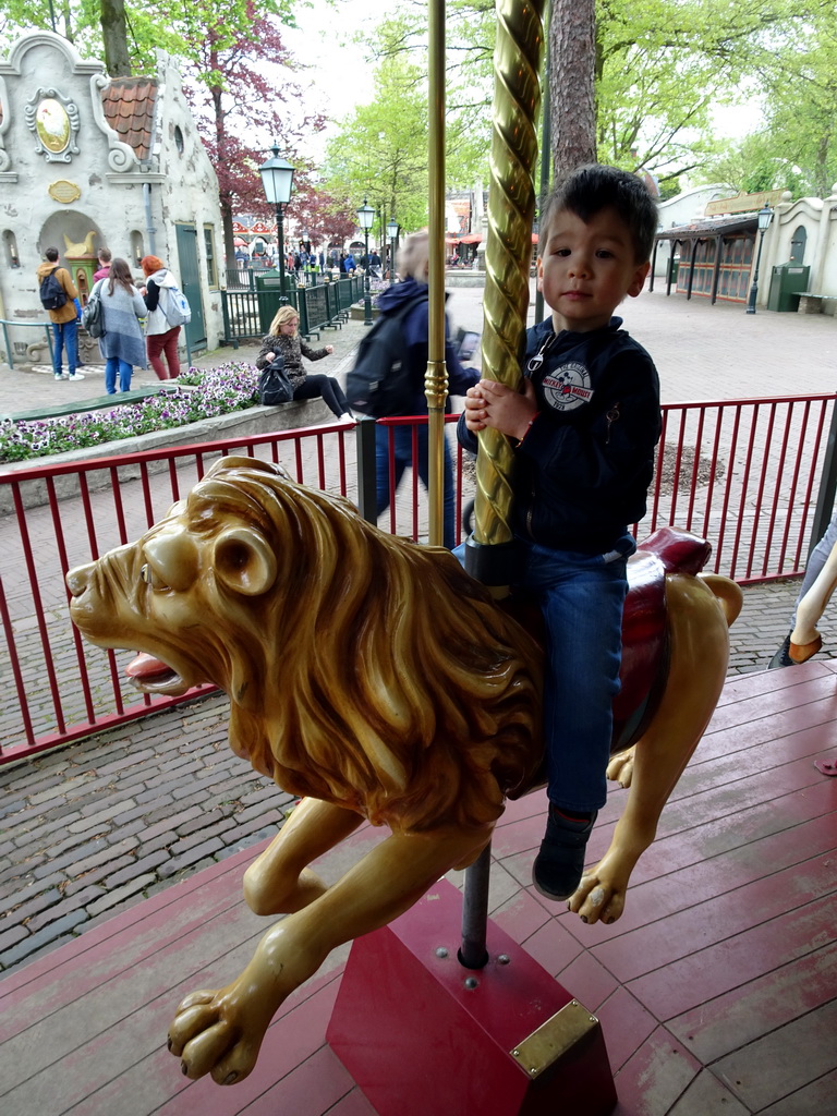 Max on a lion statue at the Vermolen Carousel at the Anton Pieck Plein square at the Marerijk kingdom