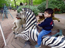 Max on a zebra statue at the Vermolen Carousel at the Kindervreugd playground at the Marerijk kingdom