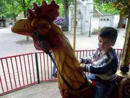 Max on a rooster statue at the Vermolen Carousel at the Anton Pieck Plein square at the Marerijk kingdom