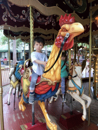 Max on a rooster statue at the Vermolen Carousel at the Anton Pieck Plein square at the Marerijk kingdom