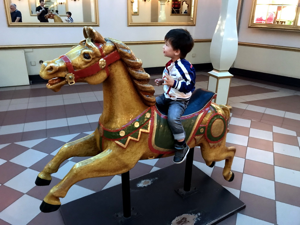 Max on a horse statue in front of the Stoomcarrousel attraction at the Marerijk kingdom