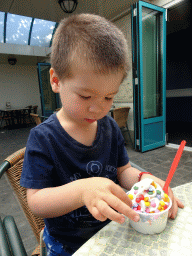 Max eating ice cream at the terrace of the Witte Paard restaurant at the Anton Pieck Plein square at the Marerijk kingdom