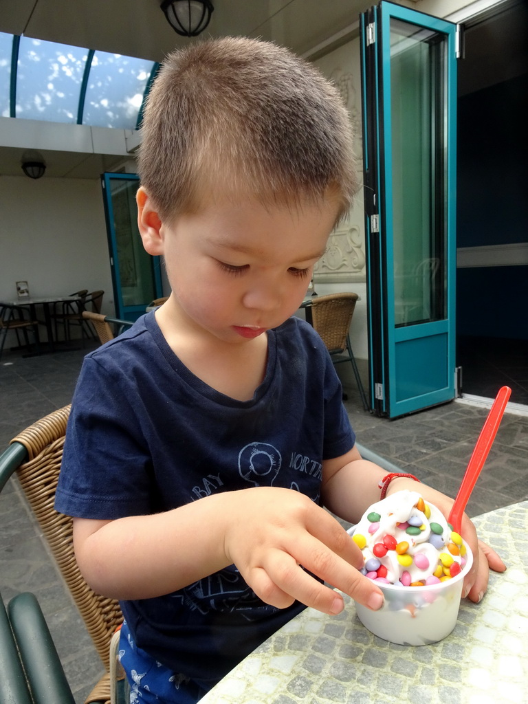 Max eating ice cream at the terrace of the Witte Paard restaurant at the Anton Pieck Plein square at the Marerijk kingdom
