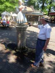 Miaomiao`s father at a fountain at the Anton Pieck Plein square at the Marerijk kingdom