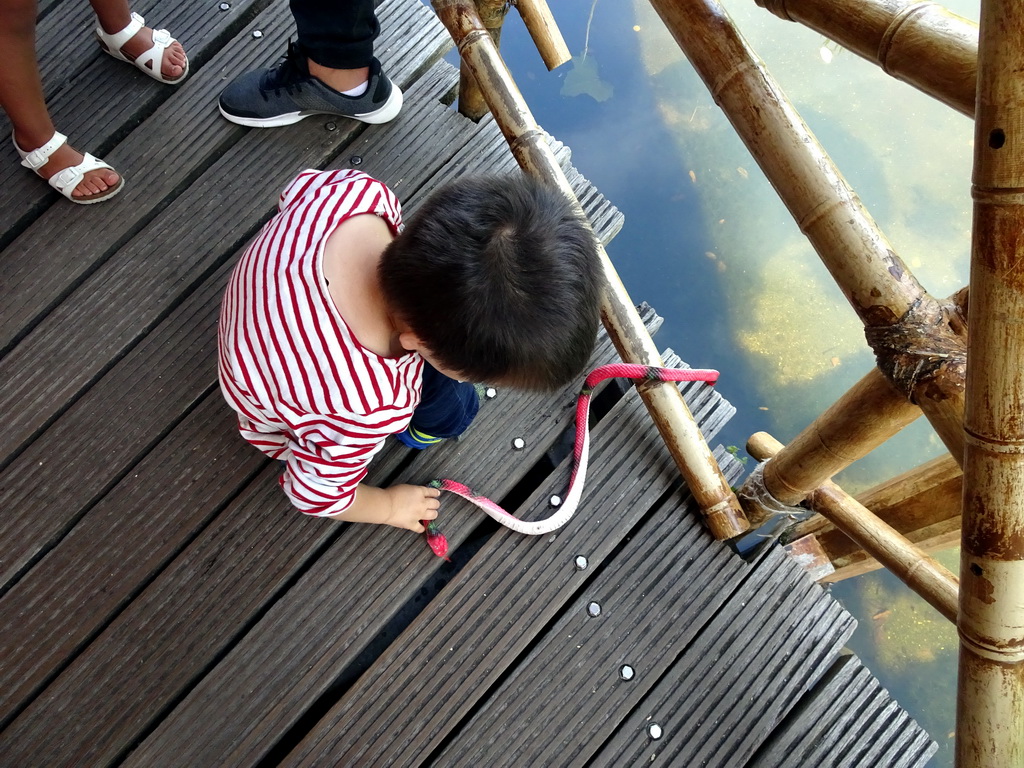 Max with a toy snake at the walking bridge to the Monsieur Cannibale attraction at the Reizenrijk kingdom