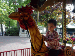 Max on a rooster statue at the Vermolen Carousel at the Anton Pieck Plein square at the Marerijk kingdom