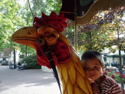 Max on a rooster statue at the Vermolen Carousel at the Anton Pieck Plein square at the Marerijk kingdom