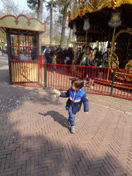 Max playing with bubbles in front of the Vermolen Carousel at the Anton Pieck Plein square at the Marerijk kingdom
