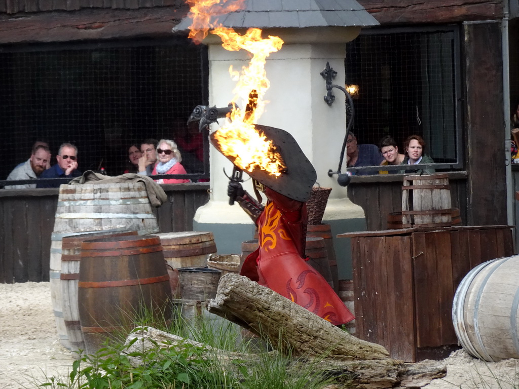 Actor and fire on the stage of the Raveleijn theatre at the Marerijk kingdom, during the Raveleijn Parkshow