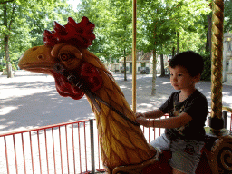 Max on a rooster statue at the Vermolen Carousel at the Anton Pieck Plein square at the Marerijk kingdom