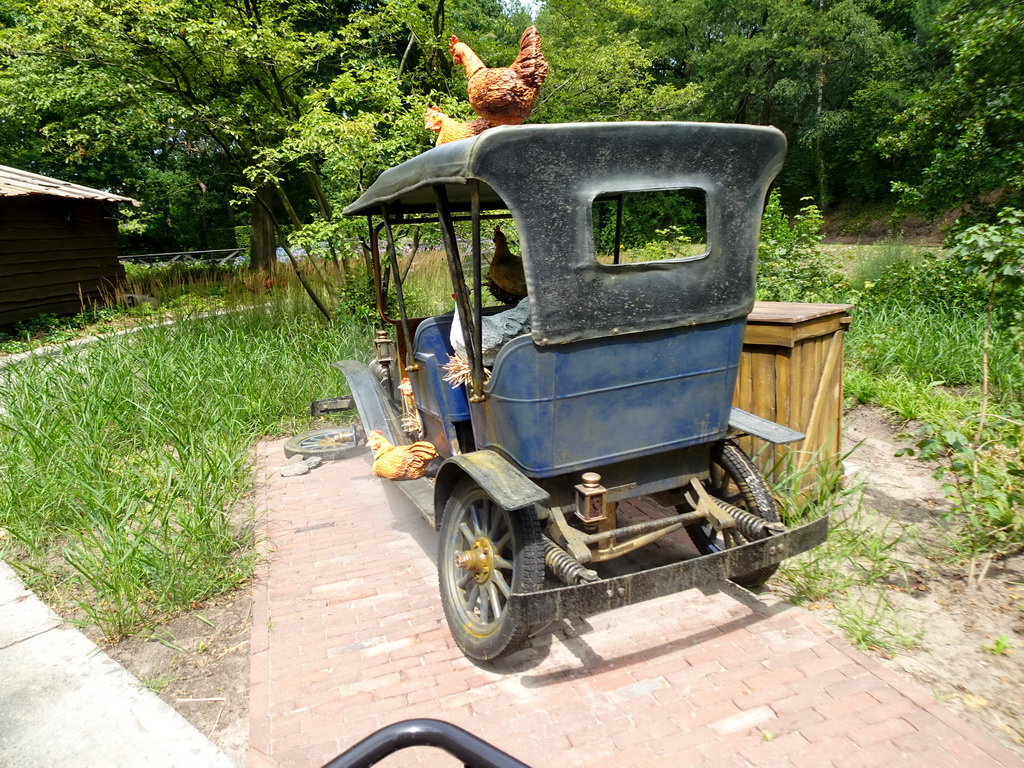 Automobile and chickens at the Oude Tufferbaan attraction at the Ruigrijk kingdom, viewed from an automobile