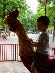 Max on a rooster statue at the Vermolen Carousel at the Anton Pieck Plein square at the Marerijk kingdom