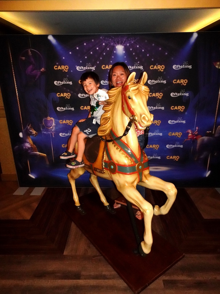 Miaomiao and Max on a carousel horse at the foyer of the Efteling Theatre at the Anderrijk kingdom