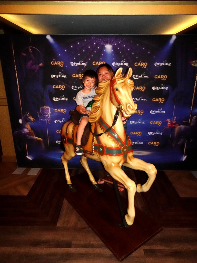 Miaomiao and Max on a carousel horse at the foyer of the Efteling Theatre at the Anderrijk kingdom