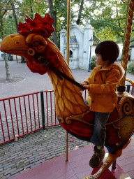 Max on a rooster statue at the Vermolen Carousel at the Anton Pieck Plein square at the Marerijk kingdom