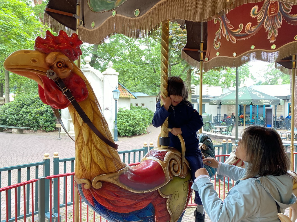 Miaomiao and Max on a rooster statue at the Vermolen Carousel at the Anton Pieck Plein square at the Marerijk kingdom