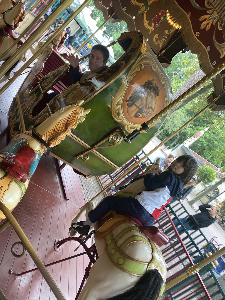 Tim and Max on a horse statue at the Vermolen Carousel at the Anton Pieck Plein square at the Marerijk kingdom