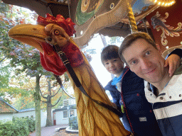 Tim and Max on a rooster statue at the Vermolen Carousel at the Anton Pieck Plein square at the Marerijk kingdom