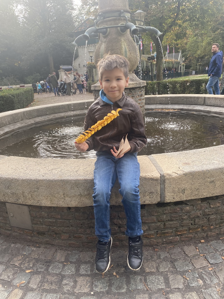 Max eating Eigenheymers at the Sint Nicolaasfontein fountain at the Sint Nicolaasplaets square at the Marerijk kingdom