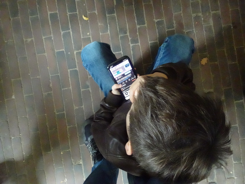Max playing with iPhone at the waiting line for the Villa Volta attraction at the Marerijk kingdom