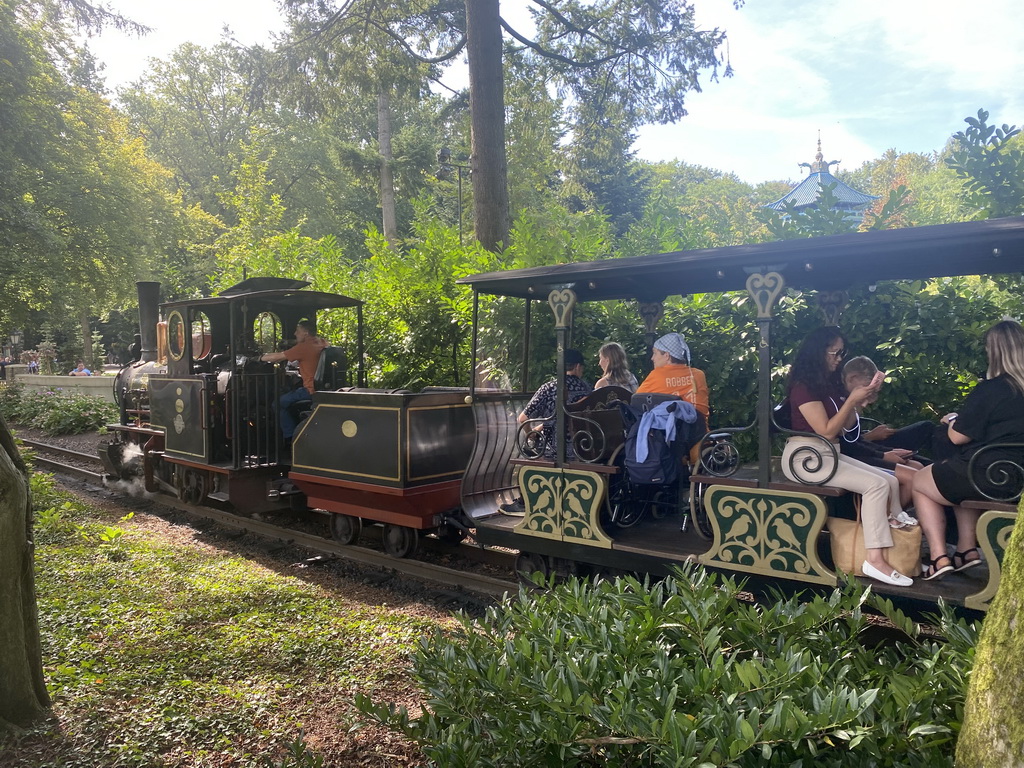 Train riding past the Anton Pieck Plein square at the Marerijk kingdom, with a view on the tower of the Chinese Nightingale attraction at the Fairytale Forest