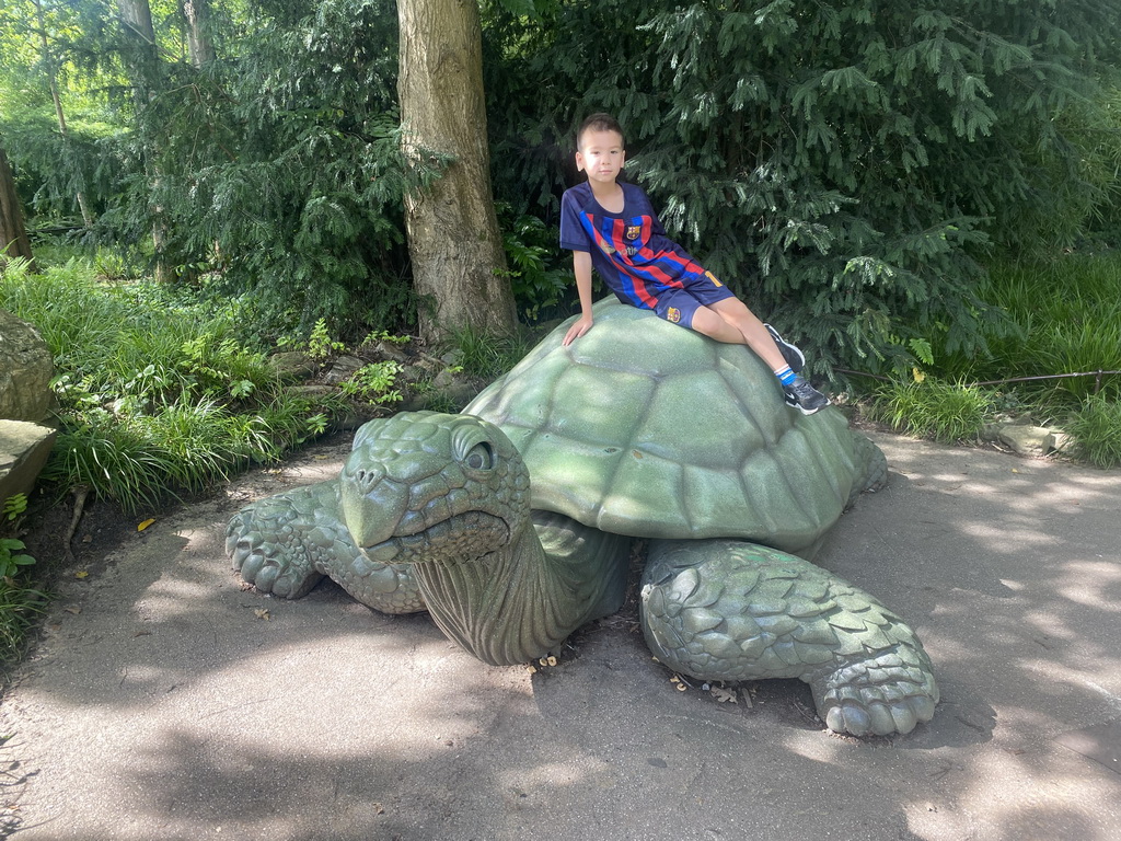 Max on the turtle statue at the waiting line for the Fabula attraction at the Anderrijk kingdom