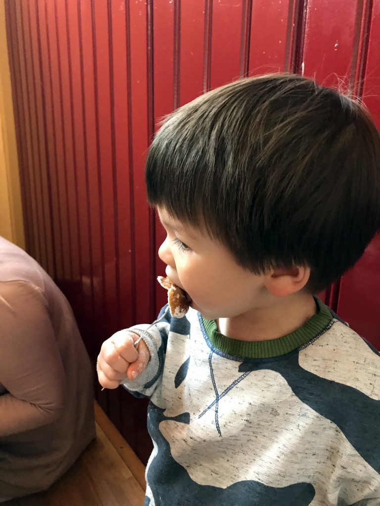 Max eating Poffertjes at the `t Poffertje restaurant at the Anton Pieck Plein square at the Marerijk kingdom