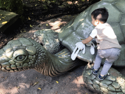 Max with a turtle statue in front of the Pandadroom attraction at the Anderrijk kingdom
