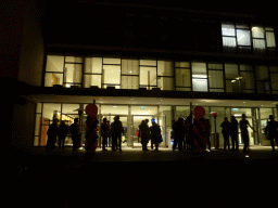 People celebrating the start of the carnival season in front of the Pullman Eindhoven Cocagne Hotel at the Tramstraat street, by night