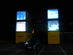 `City Loops` screens of the Storybox studio at a parking place near the Tramstraat street during the GLOW festival, by night