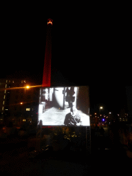 Projection screen and tower in red light at the Philitelaan street during the GLOW-NEXT festival, by night