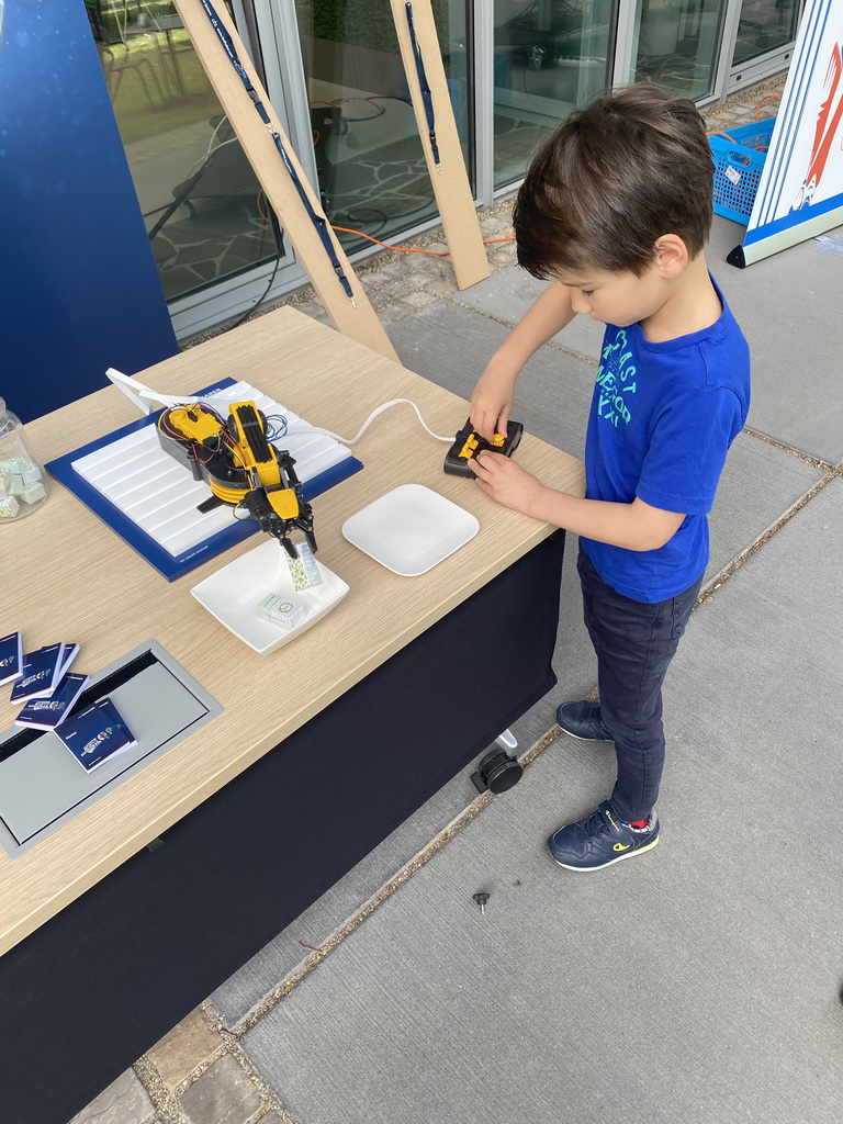 Max playing with a robot arm at the Strip area at the High Tech Campus Eindhoven, during the High Tech Campus Eindhoven Open Day 2022