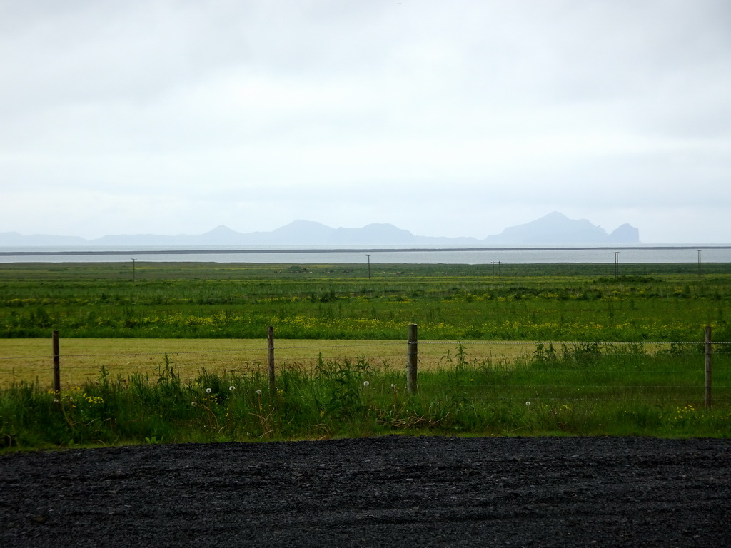 Grassland, the Atlantic Ocean and the island of Heimaey, viewed from the parking lot of the Þorvaldseyri visitor centre