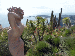 Cactuses and statue at the Jardin d`Èze botanical garden, with a view on the Mont Boron hill and the Cap-Ferrat peninsula with the town of Saint-Jean-Cap-Ferrat