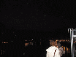 Miaomiao and her friend at the Ponte Vecchio bridge, with a view on the Ponte Santa Trinita bridge over the Arno river and the tower of the Chiesa di San Jacopo Soprarno church, by night