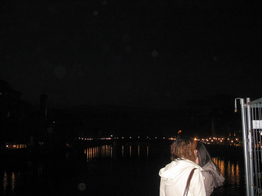 Miaomiao and her friend at the Ponte Vecchio bridge, with a view on the Ponte Santa Trinita bridge over the Arno river and the tower of the Chiesa di San Jacopo Soprarno church, by night