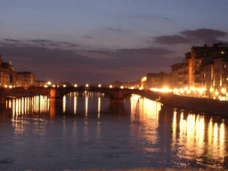 The Ponte Santa Trinita bridge over the Arno river, viewed from the Ponte Vecchio bridge, by night